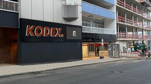 Ansicht von Gebäuden in einer Straße. Eines ist noch im Rohbau. An dem Gebäude daneben der Schriftzug "Kodex".