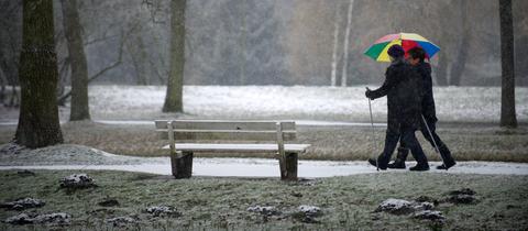 Zwei Frauen gehen bei neuerlichen Schneefällen spazieren. 