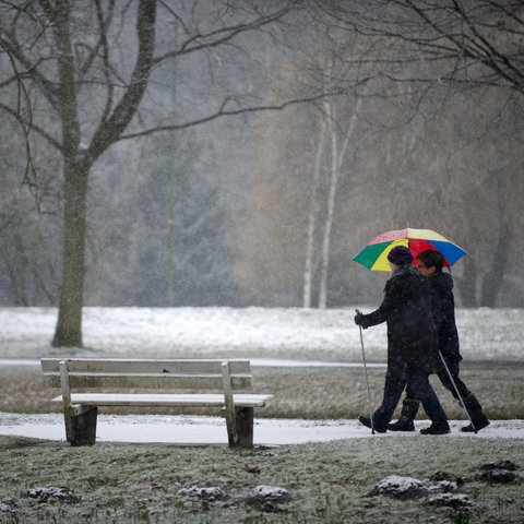 Zwei Frauen gehen bei neuerlichen Schneefällen spazieren. 