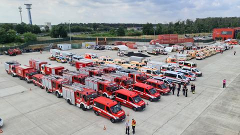 Vogelperspektive: Diverse Feuerwehrautos und Rettungswagen stehen dicht geparkt auf einem Parkplatz