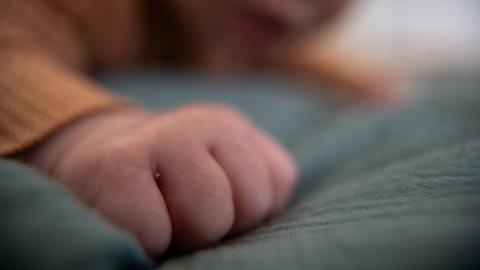 Symbolfoto: Ein Baby liegt auf einem Tuch. 