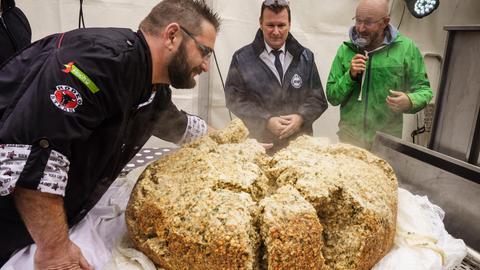 Ein riesiger Semmelknödel liegt zerbrochen auf einem Tisch.