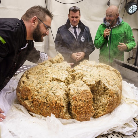 Ein riesiger Semmelknödel liegt zerbrochen auf einem Tisch.