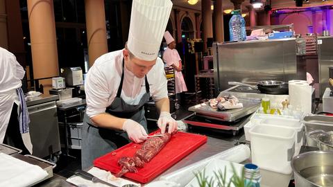 Koch schneidet Stück Fleisch