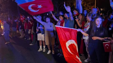 Erdoğan-Anhänger am türkischen Konsulat in Frankfurt. Türkische Fahnen werden geschwenkt.