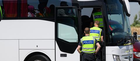 Polizisten durchsuchen bei einer Kontrolle einen Reisebus.