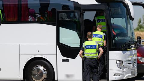 Polizisten durchsuchen bei einer Kontrolle einen Reisebus.