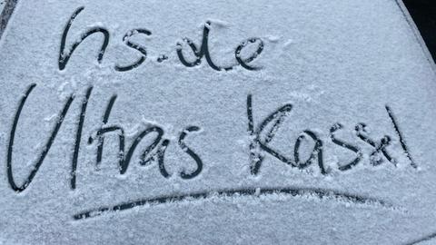 Autoscheibe mit Schnee: Darin geschrieben: hs.de Ultras Kassel