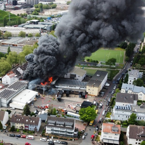 Schwarze Rauchwolke über Firmengelände von oben