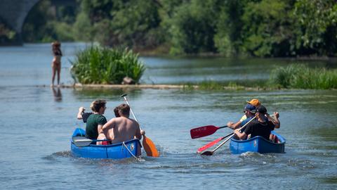 Zwei mit jeweils mehreren Personen besetzte Kanus auf der Lahn.