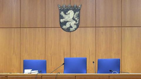 Im Gerichtssaal des Land- und Amtsgerichtes Frankfurt. Drei leere Richterstühle in Detailaufnahme, darüber hängt das hessische Wappen.