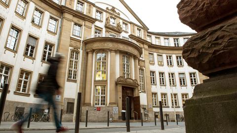 Das Land- und Amtsgericht Frankfurt von der Straße aus fotografiert. Davor ist ein Mensch zu sehen, wie er vorbeiläuft. Die Tür zum Gebäude steht offen.