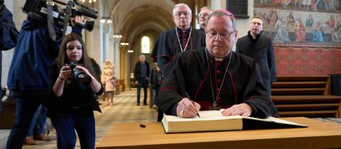 Der Limburger Bischof Georg Bätzing trägt sich im Limburger Dom in das Kondolenzbuch für den emeritierten Papst Benedikt ein. 