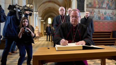 Der Limburger Bischof Georg Bätzing trägt sich im Limburger Dom in das Kondolenzbuch für den emeritierten Papst Benedikt ein. 