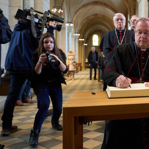 Der Limburger Bischof Georg Bätzing trägt sich im Limburger Dom in das Kondolenzbuch für den emeritierten Papst Benedikt ein. 