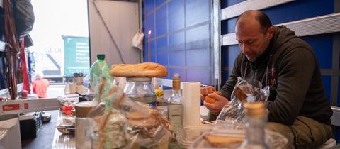 Eine Gebetskerze steckt am Ostersonntag in einem Brot auf einem provisorischen Tisch, an dem Lastwagenfahrer Zurab aus Georgien in einem Lkw auf der Raststätte Gräfenhausen sitzt.