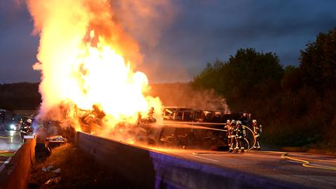 Lkw brennt, daneben Feuerwehrkräfte