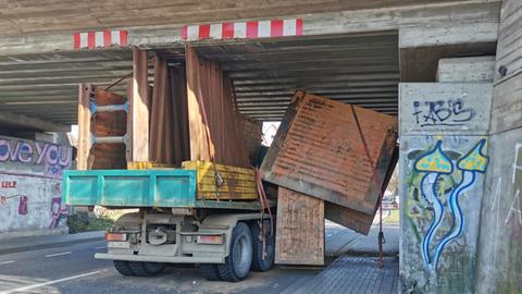Ein mit Bauteilen beladener Laster steckt in einer Bahnunterführung fest.