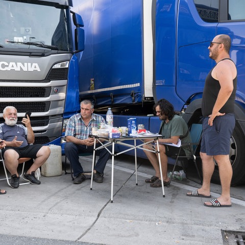 Lkw-Fahrer sitzen am Mittwoch auf der Raststätte Gräfenhausen vor ihren Fahrzeugen zusammen.