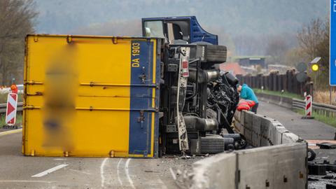 Der Lkw liegt auf die Seite gekippt auf der Fahrbahn. 