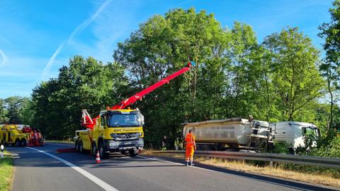 Der Lkw liegt im Gebüsch, ein Abschleppwagen steht davor.