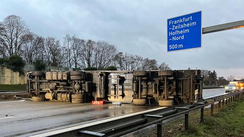 Lkw liegt quer auf der Autobahn, die Unterseite ist zu sehen. Dahinter ein Polizeiauto.