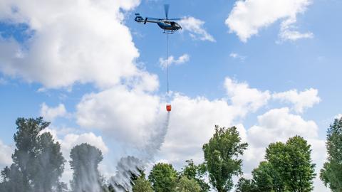 Wasser wird aus dem Löschwasserbehälter eines Polizei-Hubschraubers, auch "Bambi Bucket" genannt, entlassen. 