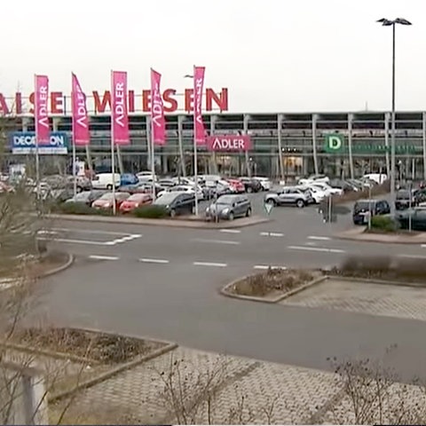 Parkplatz eines Einkaufszentrums mit Autos aus der Vogelperspektive fotografiert. 
