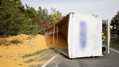 Umgekippter Lkw auf Straße, Mais liegt auf Straße und in Böschung