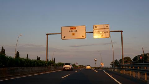 Auf einer Autobahn hängen Schilder mit der Aufschrift "Palma" und "Son Gual".