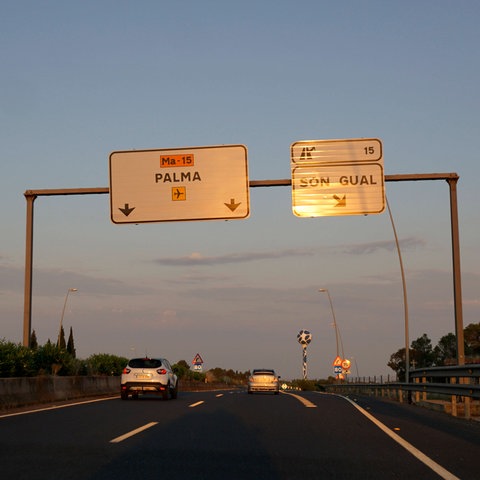 Auf einer Autobahn hängen Schilder mit der Aufschrift "Palma" und "Son Gual".