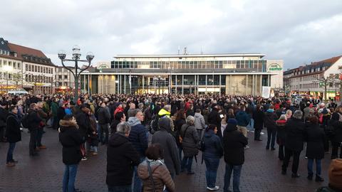 Mehrere hundert Menschen haben sich bei der Übertragung der Trauerfeier auf dem Marktplatz in Hanau versammelt.