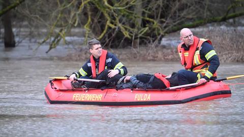 Zwei Feuerwehrleute und der gerettete Mann in einem Schlauchboot