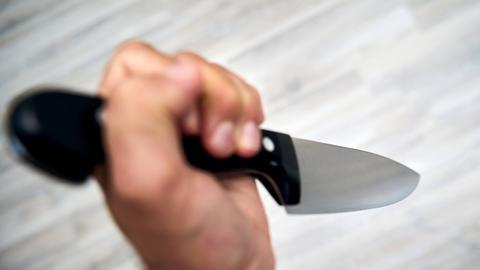 Eine Hand hält ein gefährliches Messer.