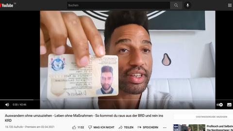 Reichsbürger David Ekwe-Ebobisse zeigt seinen Personalausweis vom "Königreich Deutschland"