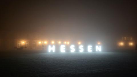 Schloss Biebrich in Wiesbaden im Nebel, davor die Leuchtschrift "Hessen"