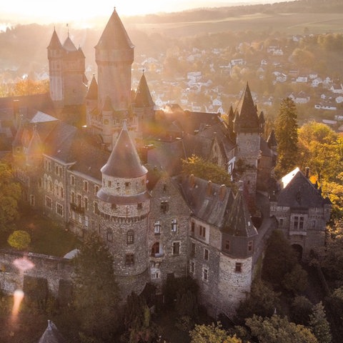 Sonnenaufgang hinter Schloss Braunfels, aus der Vogelperspektive fotografiert.