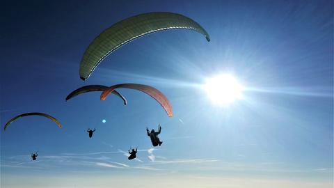 Vier Paraglyder am Himmel über der Wasserkuppe. 