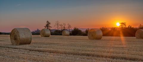 "Sommerzeit ist Erntezeit: Die Getreidefelder im Braunfelser Land sind abgeerntet. Zurück bleiben riesige Strohballen,  die von der untergehenden Sonne in ein malerisches Licht getaucht werden." Den Moment hat hessenschau.de-Nutzer Axel Junker mit seiner Kamera festgehalten.