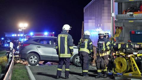 Querstehender Kleinwagen, der mit der Front in die Seite eines Lakstwagend geprallt ist, davor Feuerwehrleute