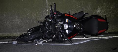 Ein schwarzes Motorrad liegt auf der Fahrbahn der A66.