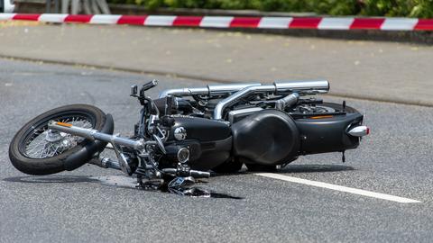 Ein Motorrad liegt auf der Seite auf einer Straße.