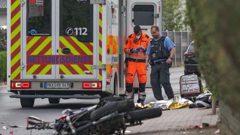 Rettungssanitäter stehen neben dem beschädigten Motorrad.