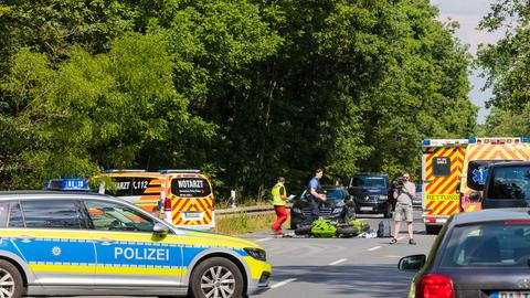 Einsatzfahrzeuge auf der Straße rund um das zerstörte Motorrad.