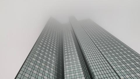 Ein Hochhaus ragt in den nebligen Himmel.