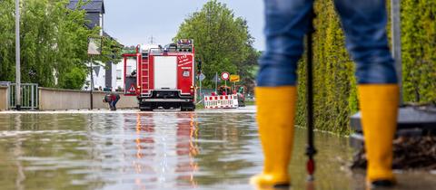 Feuerwehrleute arbeiten in einer überschwemmten Straße. 