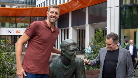 Dirk Nowitzki (l), ehemaliger Basketball-Nationalspieler, steht nach der Enthüllung einer Nowitzki-Statue des Berliner Bildhauers Andreas Artur Hoferick (r) vor dem Hauptsitz der Direktbank ING Deutschland in Frankfurt.
