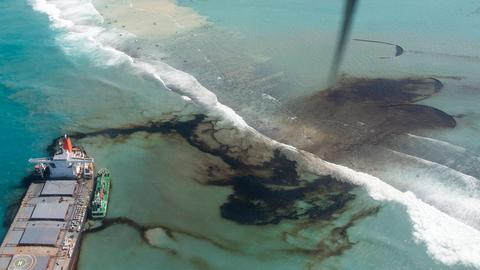 Foto (Vogelperspektive), das zeigt, wie Öl aus einem Schiff in das Meer strömt.