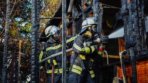 Feuerwehrleute im Einsatz in brennender Gartenhütte