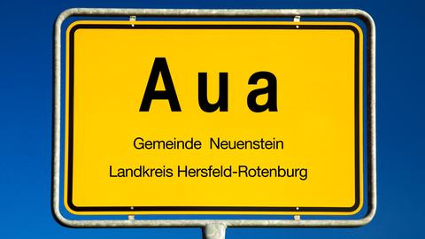 Auf einem Ortsschild steht "Aua".